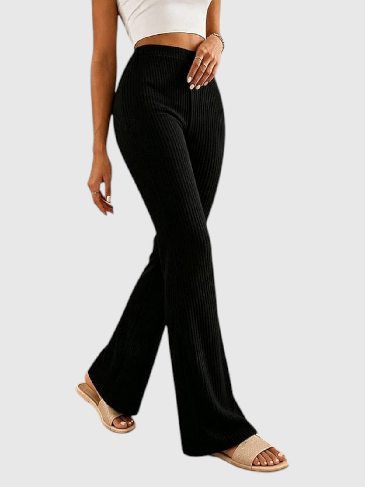My Store Sophia black high-waisted ribbed flare pants worn by a model with beige slide sandals